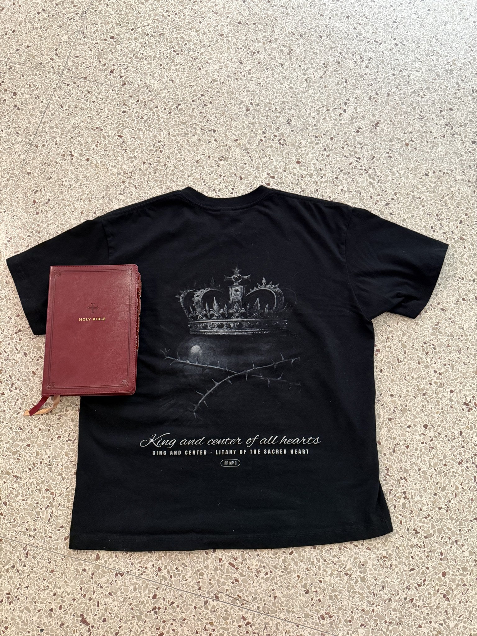 King and Center engraved back print with Bible, black tee, flat lay