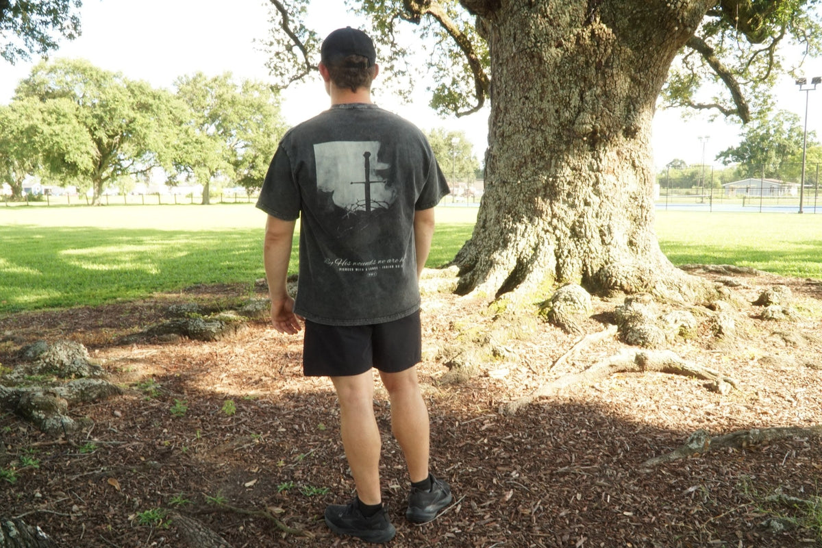 Pierced with a Lance back print worn, washed black tee