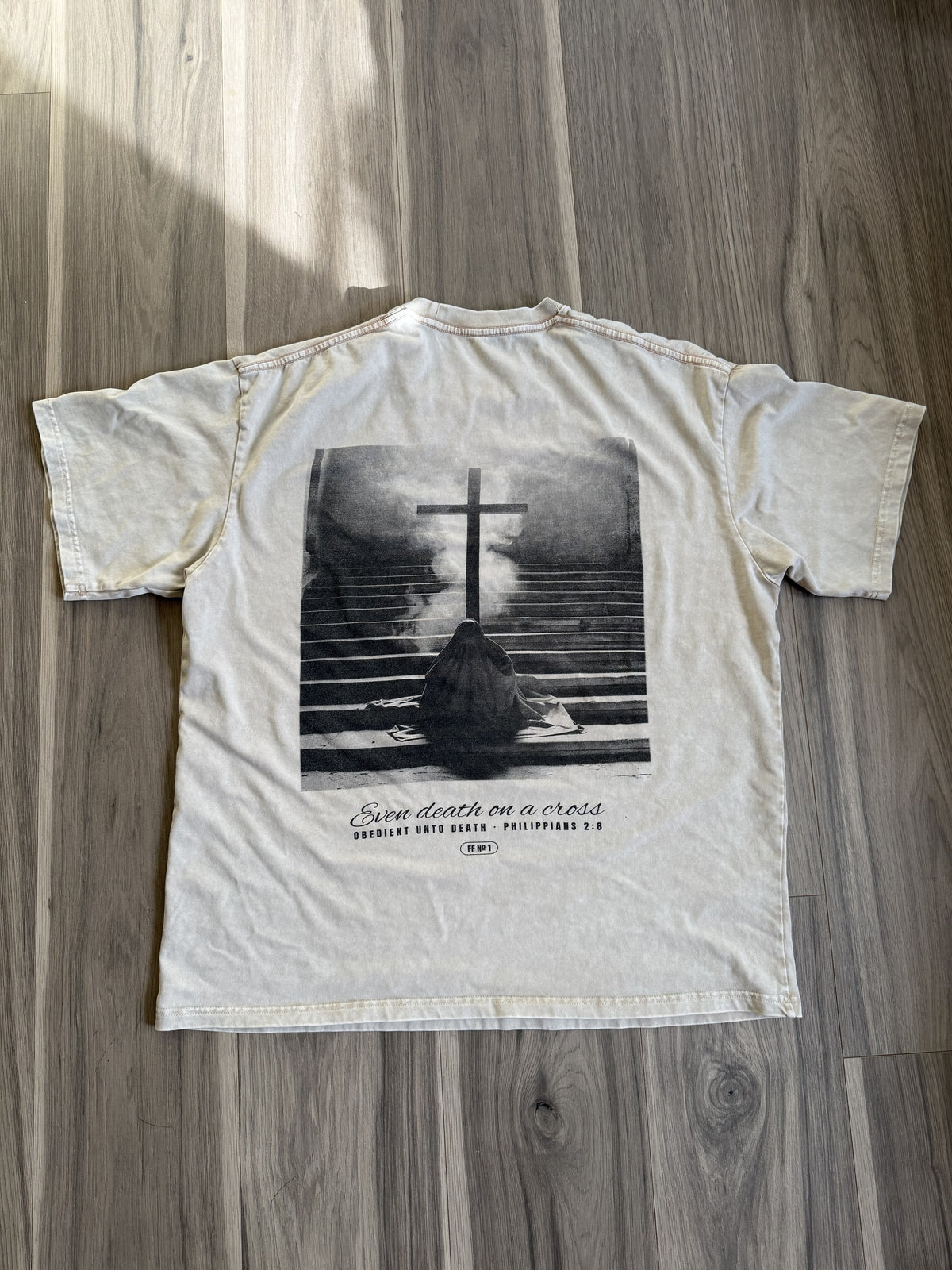 Obedient Unto Death back print, apricot tee, flat lay
