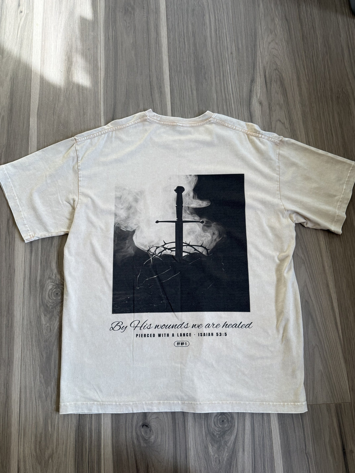 Pierced with a Lance back print, apricot tee, flat lay